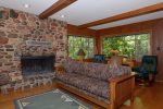 The living area has a large stone clad wood burning fireplace